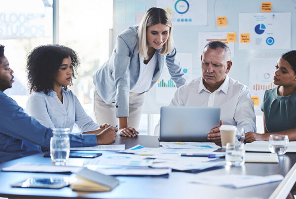 saas professional services team gathered around conference room table reviewing client project