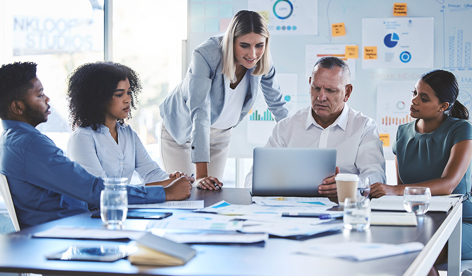 saas professional services team gathered around conference room table reviewing client project