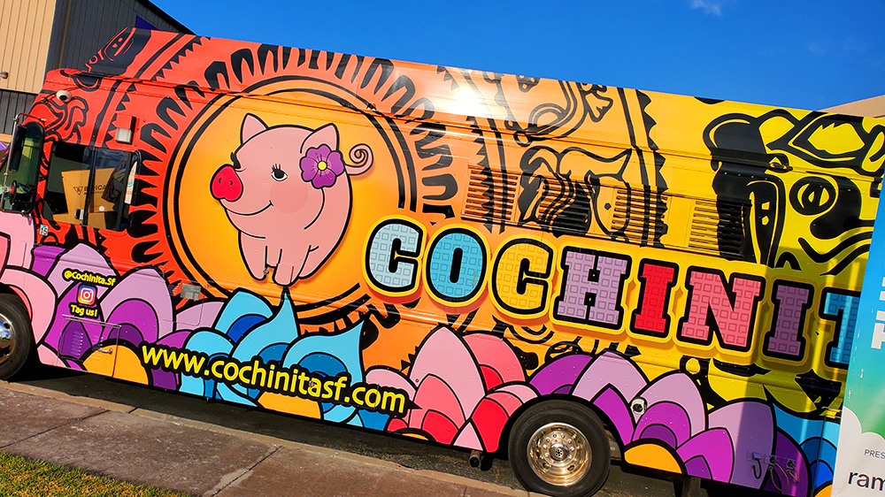 Brightly colored food truck with yellow, orange, blue, pink grafitti and Cochinita logo