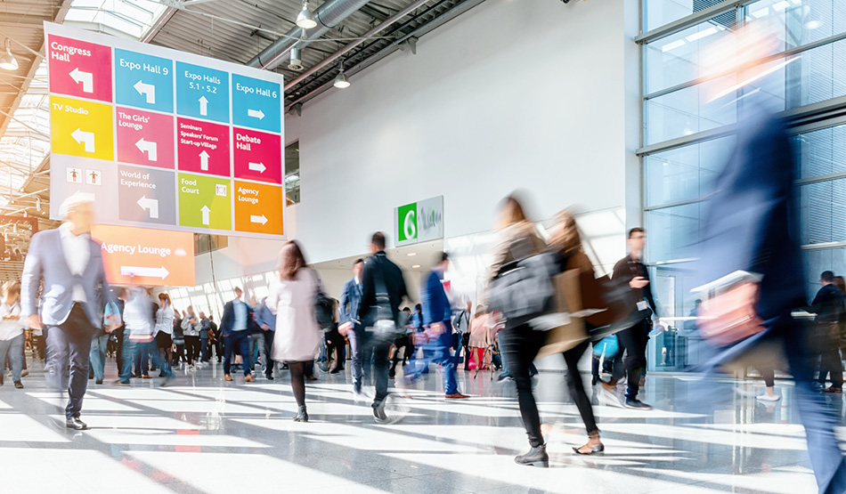 attendees walking hall of tradeshow exhibit