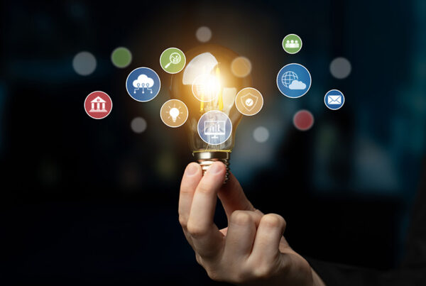 business man holding a light bulb with marketing tech stack icons floating in air
