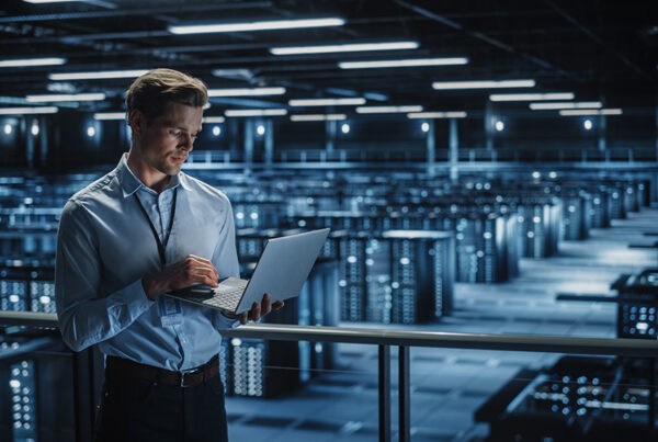 it director in data center viewing software-as-a-service applications on laptop