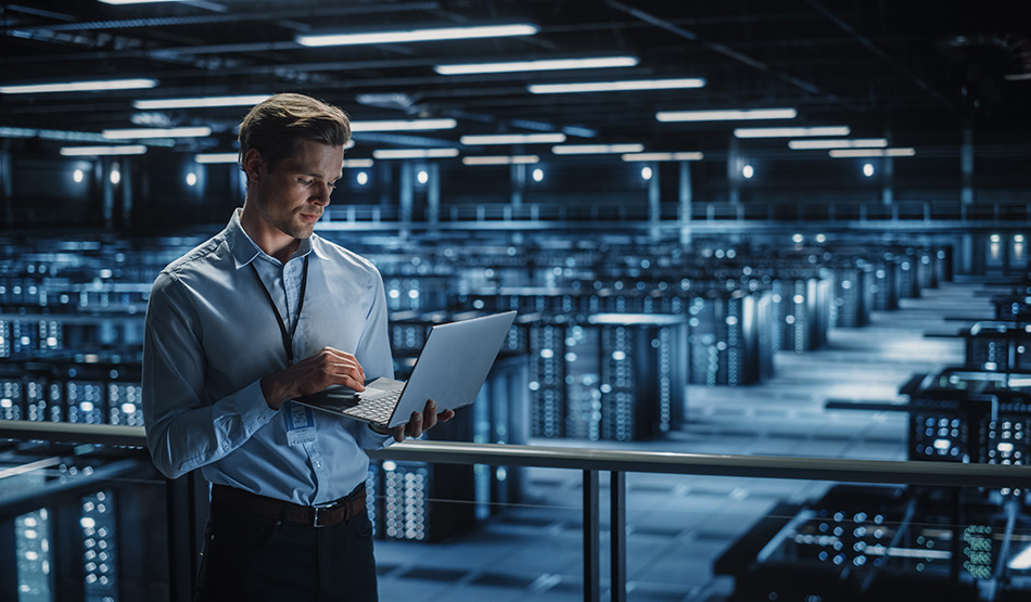 it director in data center viewing software-as-a-service applications on laptop